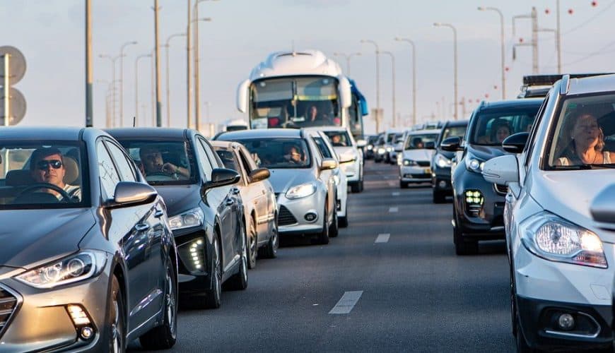 Embouteillage sur plusieurs voies avec voitures et bus par temps clair.